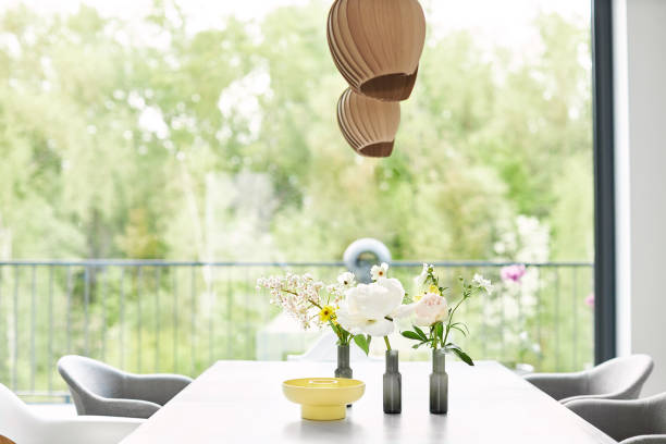 Different photos of a decorated white dining table in a bright environment with flowers and a flower vase