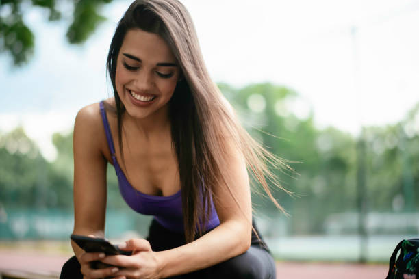 istock Young athlete woman sitting on bench and using the phone. 1252271452