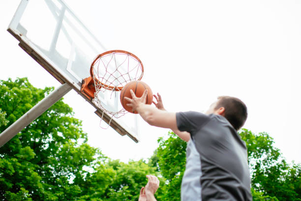 istock Two young men playing basketball in the park. 1252271610