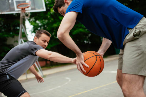 istock Two young men playing basketball in the park. 1252271611