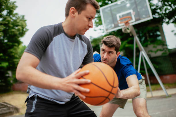 istock Two young men playing basketball in the park. 1252272119