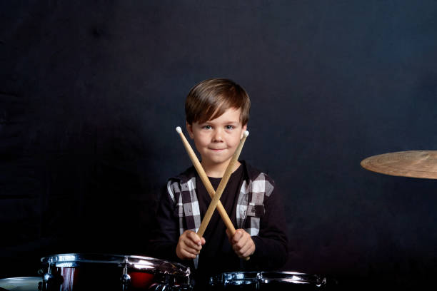 istock The child sits with drumsticks in his hands. Studying in the studio. 1252278549