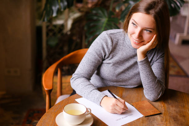 istock Girl filling visa application, passport and cup on table 1252284811