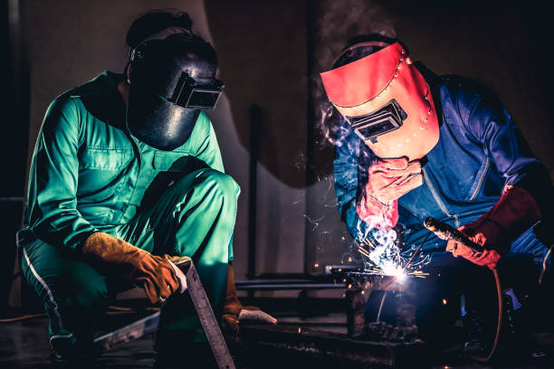 Metal welding steel works using electric arc welding machine Metal welding steel works using electric arc welding machine to weld steel at factory. Metalwork manufacturing and construction maintenance service by manual skill labor concept. metalwork stock pictures, royalty-free photos & images