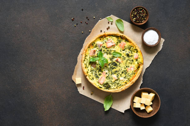 quiche (pie) with salmon, spinach and soft cheese on a dark concrete background. view from above. - baked breakfast cabbage cake imagens e fotografias de stock