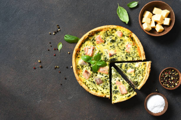 quiche (pie) with salmon, spinach and soft cheese on a dark concrete background. view from above. - baked breakfast cabbage cake imagens e fotografias de stock