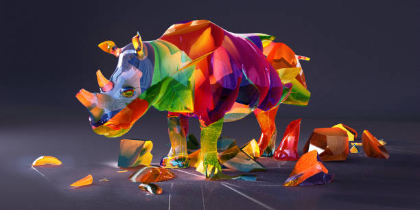 A conceptual image of a rhino - one of the most endangered species - comprised of multi coloured precious gemstones, fracturing apart with pieces fallen on the ground. Against a dark background with copyspace.