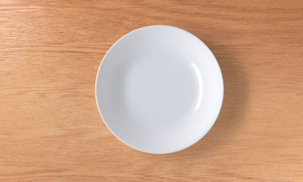 istock A blank white ceramic plate on a wooden table, top view 1252292958