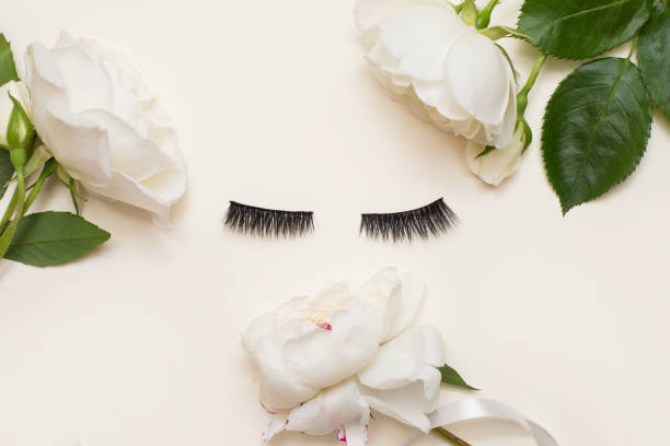 istock False eyelashes on light white background with white summer flowers with a copy space 1252295280