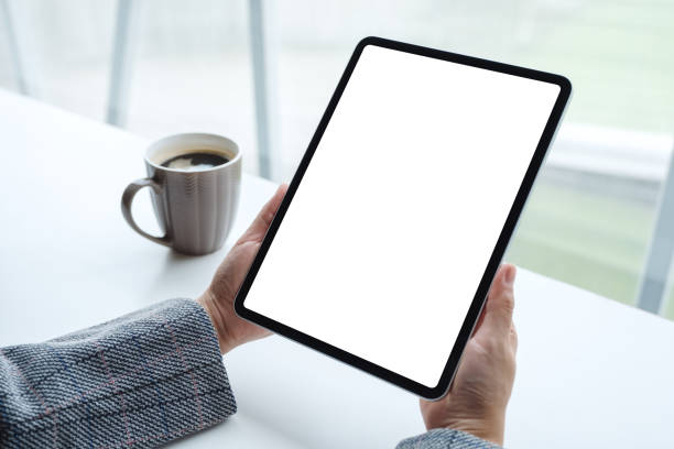istock a woman holding black tablet pc with blank white screen with coffee cup on the table 1252295359