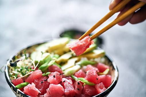 Sliced raw tuna, rise and vegetables in bowl