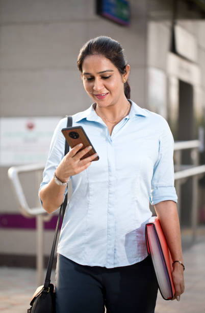 istock Businesswoman using phone outside office building 1252297029