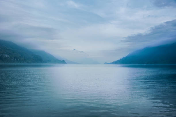 istock on the horizon - blue lake with cloudy sky 1252300076