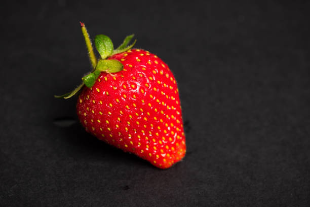 istock Fresh and ripe strawberry fruit on black background 1252317842