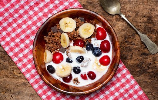 Breakfast cereals granola mix with milk and berry fruit in a bow tabletop