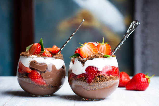 Strawberry parfait dessert in a glass cup with cream and chocola Strawberry parfait dessert in a glass cup with cream and chocolate closeup parfait photos stock pictures, royalty-free photos & images