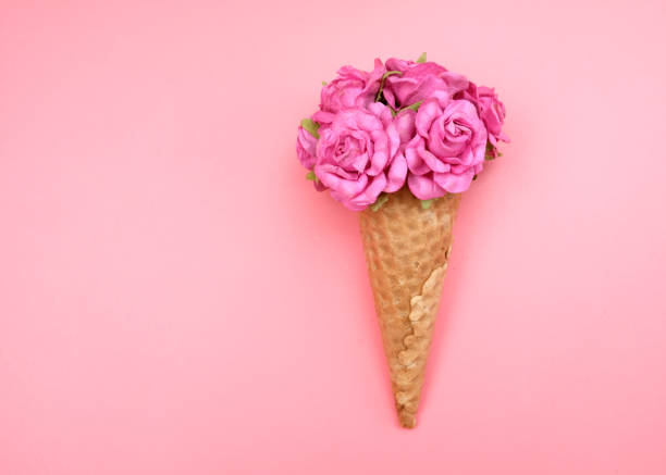 istock Waffle cone with flowers on pink background. Decorations for birthday, anniversary, wedding. Minimal decorative holiday concept. 1252319631