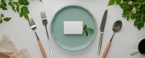 istock Cerebration dinning set with turquoise ceramic plate with white place card, silverware and decoration on white dinning table 1252320350