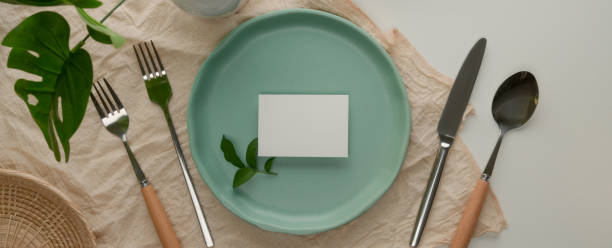 istock Dinning set with turquoise ceramic plate with white place card, silverware on tablecloth 1252320358