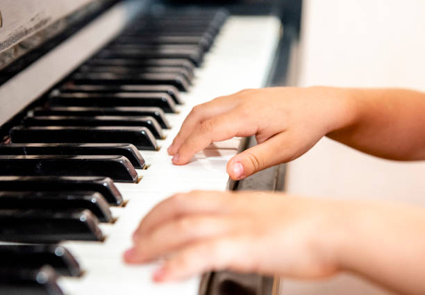 istock Close up of a little student's hands is playing, learning and practicing the piano. Piano chords In the key of C major. Music abilities for kids. Hobby and activity for the children. Selective focus. 1252324034