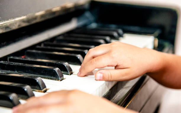 작은 학생의 손을 가까이에서 연주, 학습 및 피아노 연습. 피아노 코드 c 전공의 키에. 아이들을위한 음악 능력. 아이들을위한 취미와 활동. 선택적 초점. - piano piano key orchestra close up 뉴스 사진 이미지