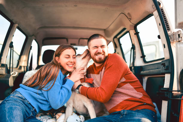 istock Cute Couple On A Road Trip With Pet Dog In Minivan 1252324113