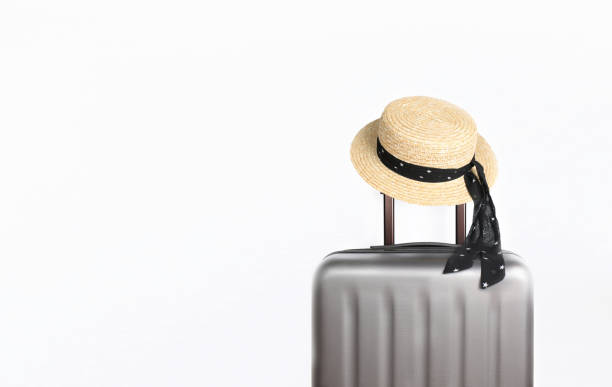 istock Suitcase with hat on light grey background with place for text. Minimal creative travel concept 1252324264