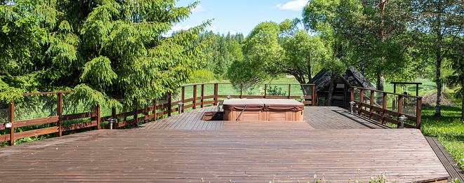 Outdoor hot tub. Wooden terrace with massage bath. Design of a country vacation spot, Finland