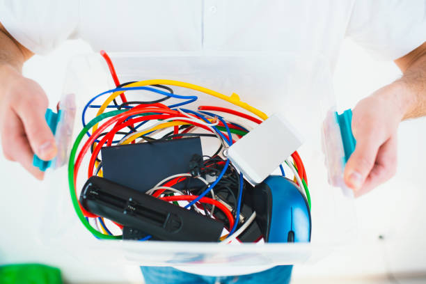 istock Young man isolated over white background. Cut view of man's hands holding plastic box with cords and batteries. Recycling process and no waste lifestyle. 1252330827