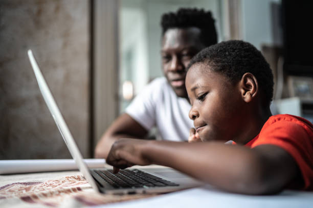 istock Father and son studying with laptop on a online class at home 1252331400