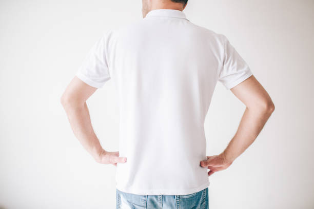istock Young man isolated over white background. Cut back view of guy holding hands on hips. Posing alone in studio. 1252331505