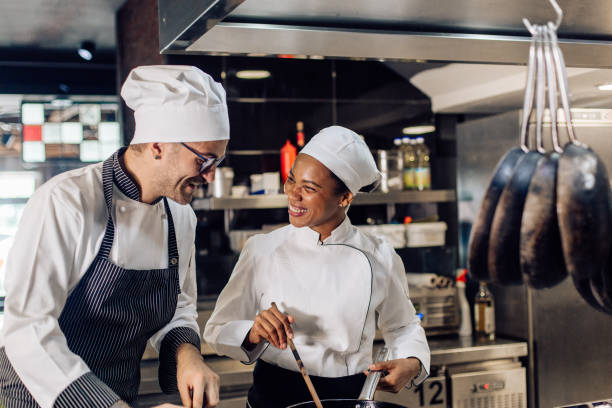 istock Young woman learning from the chef how to cook at the restaurant kitchen 1252338144