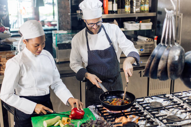 istock African-American woman helping chef at the restaurant kitchen 1252338146