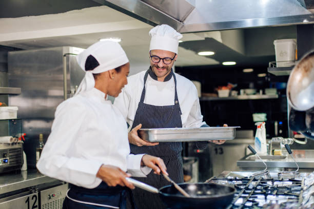 istock New employee cooking at the restaurant kitchen under the chef's supervision 1252338148