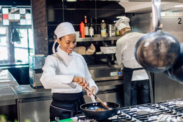 istock African-American cooker working at the restaurant kitchen, together with her chef 1252338664
