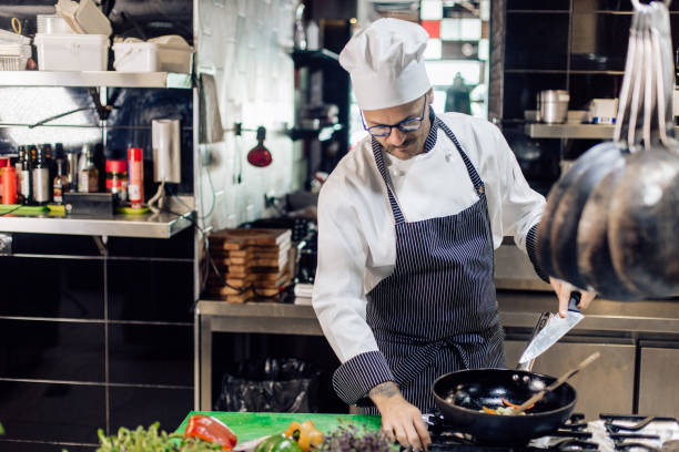 istock Chef preparing a meal at the restaurant kitchen 1252338667