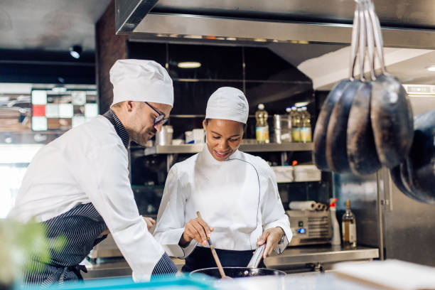 istock Chef from the restaurant kitchen teaching a new employee to cook 1252338673