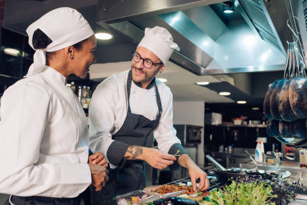 istock Experienced chef is guiding a new employee how to cook 1252338677