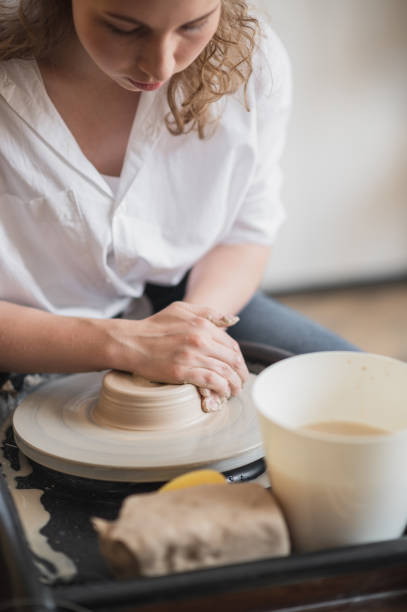 istock Hands of a potter, creating an earthen jar on the circle 1252339345