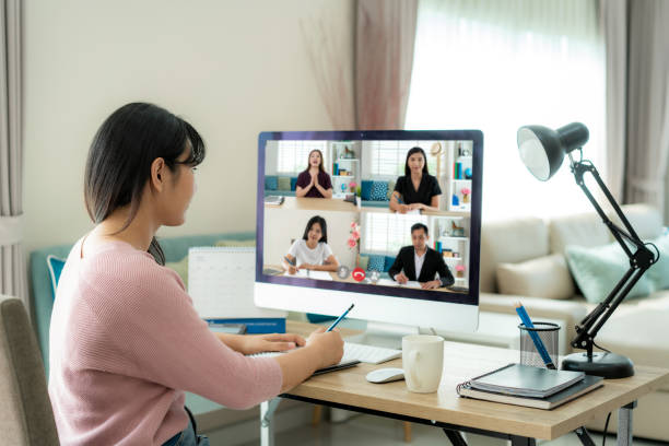 Back view of Asian business woman talking to her colleagues about plan in video conference. Multiethnic business team using computer for a online meeting in video call. Group of people smart working from home. Back view of Asian business woman talking to her colleagues about plan in video conference. Multiethnic business team using computer for a online meeting in video call. Group of people smart working from home. work from home stock pictures, royalty-free photos & images