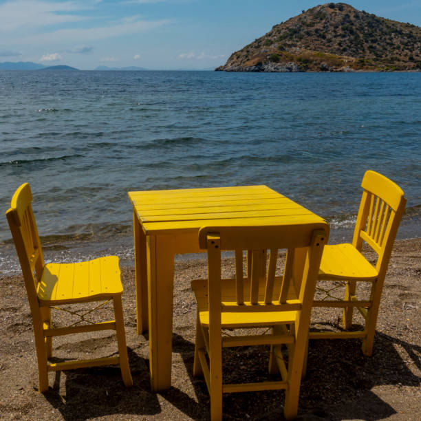 istock Yellow retro wooden chairs and a table on the beach 1252342131