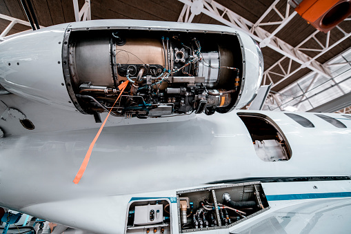 An opened jet engine of a small aircraft ready for service.