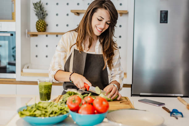 istock Young woman prepares a healthy drink in kitchen 1252362091
