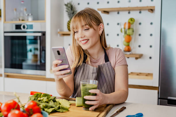 istock Young woman is in the kitchen and she is using mobile phone 1252362114