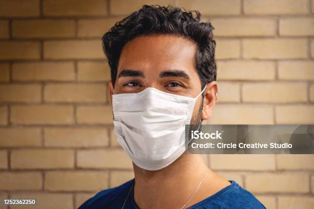 Young Man Smiling Behind The Mask During Covid19 Stock Photo - Download Image Now - Adult, Adults Only, Avoidance