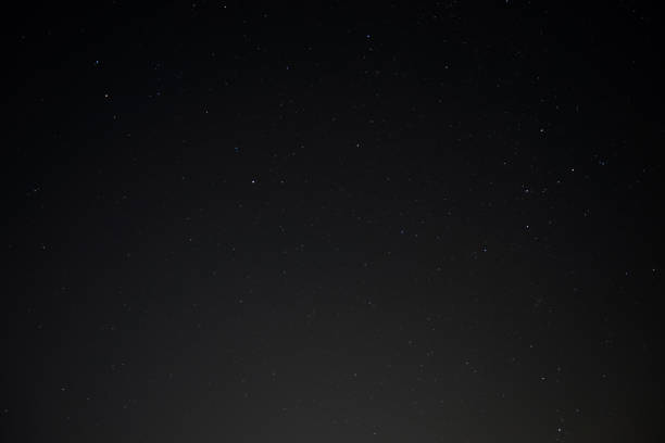 istock Stars and plane light trials in the night sky 1252364437