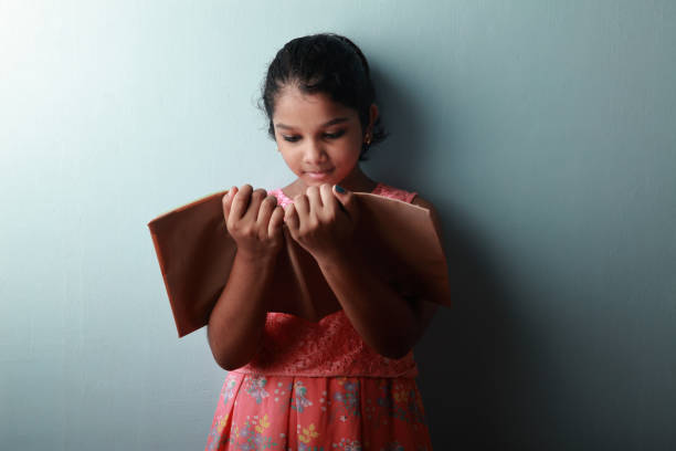 маленькая девочка читает ее записку книги - little girls pre adolescent child standing isolated стоковые фото и изображения