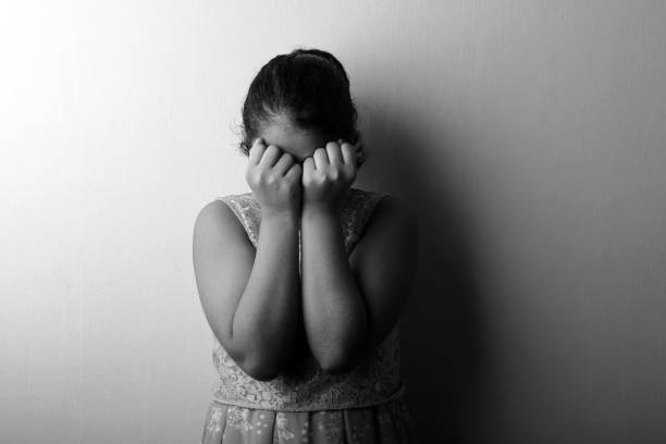 black and white image of a girl feeling guilty covering her face with hands - facial expression child asia asian and indian ethnicities imagens e fotografias de stock