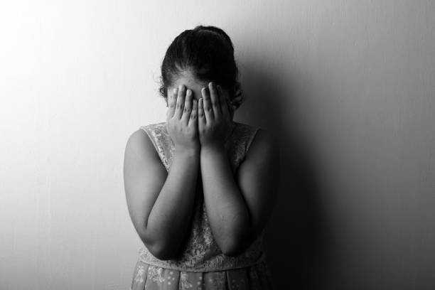 black and white image of a girl feeling guilty covering her face with hands - facial expression child asia asian and indian ethnicities imagens e fotografias de stock