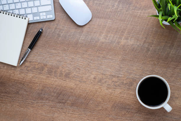 istock Wood office desk table with keyboard, notebook and coffee cup with equipment other office supplies. Business and finance concept. Flat lay with blank copy space, top view. 1252374873